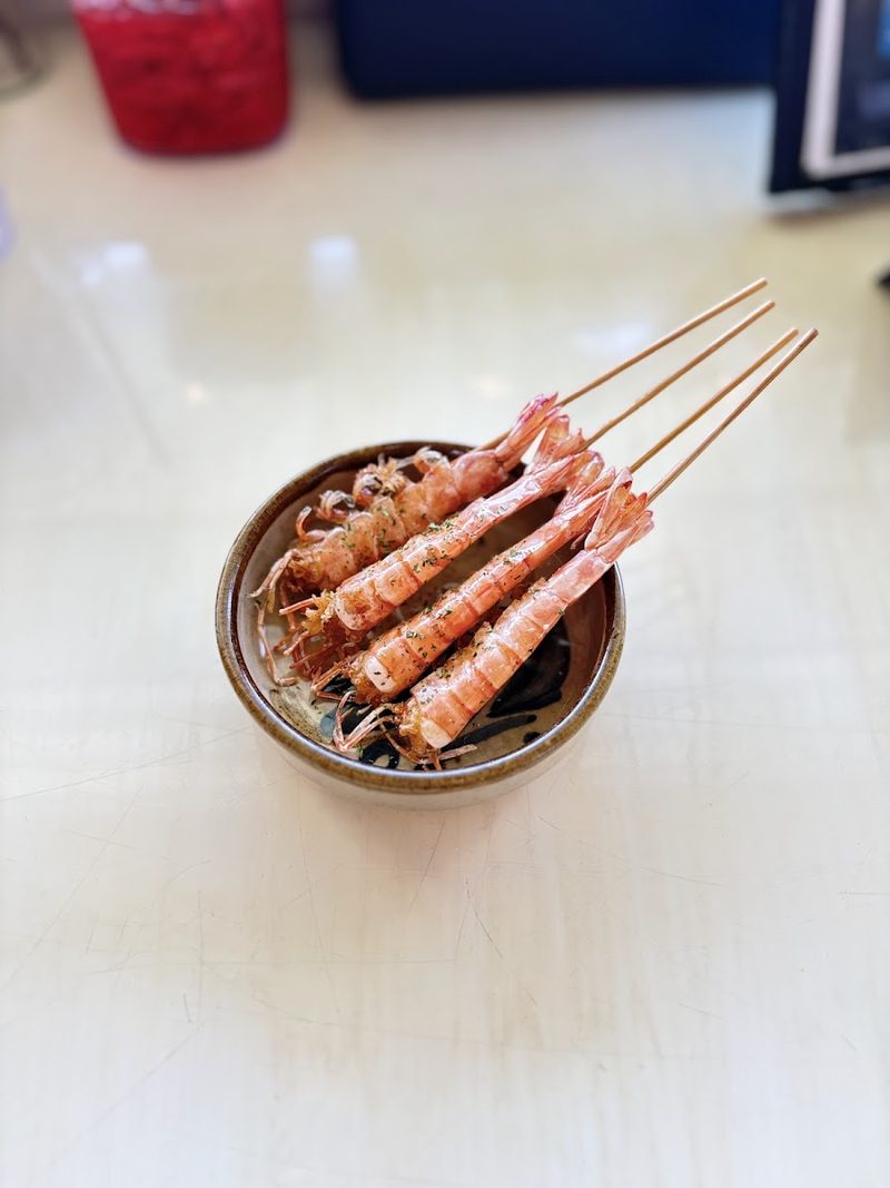 串に刺して焼き上げたえびを小鉢に盛った一品